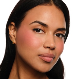 Model with YSL Make Me Blush Bold Blurring Blush in Rose Haze 6, showing soft peachy-pink blush on cheeks and a natural makeup look.
