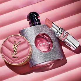 YSL Make Me Blush Bold Blurring Blush in Rose Haze 6, styled alongside Black Opium fragrance and a nude lipstick on a pink background.