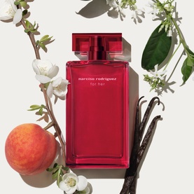 Narciso Rodriguez For Her Eau de Parfum Intense 50ml in deep red bottle, surrounded by peach, vanilla pods and white blossoms