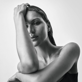 Model with NARCISO RODRIGUEZ For Her Eau de Parfum Intense 50ml, close-up beauty portrait with arms raised, monochrome shot