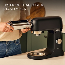 Kenwood kMix Sleek Black Stand Mixer with pasta roller attachment being fitted, shown in a kitchen setting