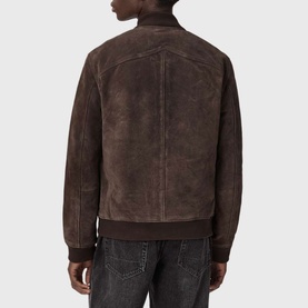 Model wearing All Saints woodland brown suede bomber jacket, rear view, styled with dark denim jeans