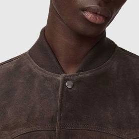 Model wearing All Saints woodland brown suede bomber jacket, close-up of snap-button collar detail