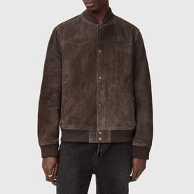 Model wearing All Saints woodland brown suede bomber jacket with ribbed collar, cuffs and hem, styled with dark jeans