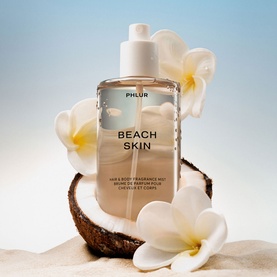 PHLUR Beach Skin Hair and Body Mist 240ml, clear bottle with white cap, styled with coconut and frangipani flowers on sand