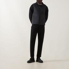 Model wearing Boss Green Label Water Repellent Gilet in black, padded sleeveless design with stand-up collar, styled with black trousers and shoes