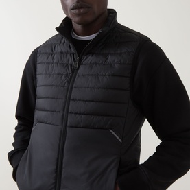 Model wearing Boss Green Label Water Repellent Gilet in black, padded front, stand-up collar, full zip, styled over black long-sleeve top.