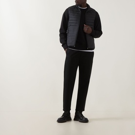Model wearing Boss Green Label Water Repellent Gilet in black, styled with black trousers, crew-neck top and black leather shoes.