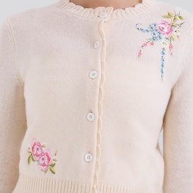 House of CB Anjou Knitted Cardigan in cream with pink floral embroidery, scallop neckline, white button-down front and ribbed trim detail.