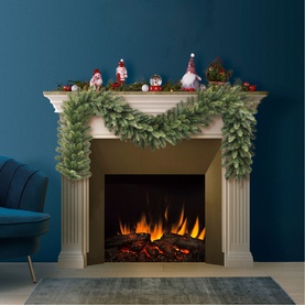 Puleo Lowa Garland 9ft draped over a white fireplace mantel, styled with festive gnome figurines and red baubles, lit fire below