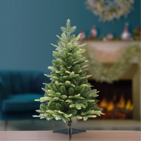 Puleo Lowa Christmas Tree 3ft with lifelike green PE/PVC needles on metal stand, styled in a cosy living room with fireplace backdrop