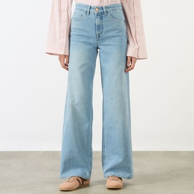 Model wearing Salsa Faith High-Rise Wide Leg Jeans in light blue with whiskering detail, styled with a pink blouse and nude flats.