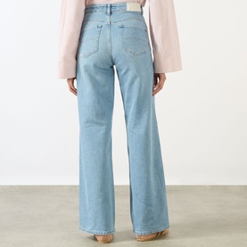Model wearing Salsa Faith High-Rise Wide Leg Jeans in light blue denim, rear view, styled with a pale pink wide-sleeve top.