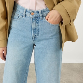 Model wearing Salsa Faith High-Rise Wide Leg Jeans in light blue denim, styled with a camel blazer. Five-pocket design with copper button detail