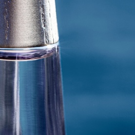 Issey Miyake L'Eau d'Issey Eau de Parfum Intense 50ml, close-up of clear glass bottle with silver cap against blue background