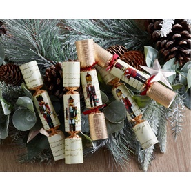 Robin Reed Nutcracker Christmas Crackers set of six, multi-coloured with red ribbon ties, styled on a festive evergreen and pinecone arrangement