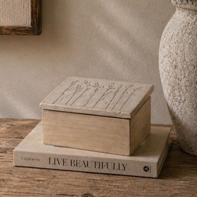 Mindy Browne Meadows Floral Square Box in white and brown wood with engraved floral lid detail, styled on books beside a textured vase.