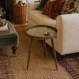 Mindy Browne Oriental Floral Round Side Table in gold, with floral-etched tray top and tapered legs, styled in a cosy living room setting.