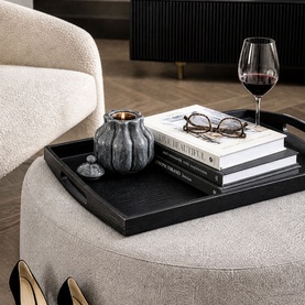 Mindy Browne Ivar Ceramic Candle Holder in grey charcoal, styled on a black tray with books and a wine glass on a cream ottoman.