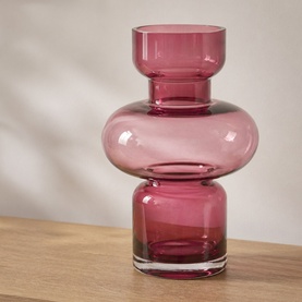Pink tiered glass vase with stacked bubble silhouette and clear base, displayed on a wooden surface