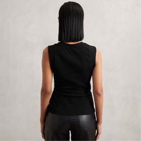 Model wearing Reiss black sleeveless top, back view, styled with black leather trousers.