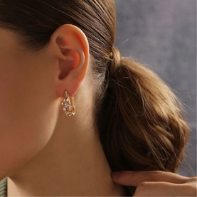 Model with Newbridge Mixed Stone Hoop Earrings in gold, featuring coloured glass and crystal stone settings on a small gold-plated hoop