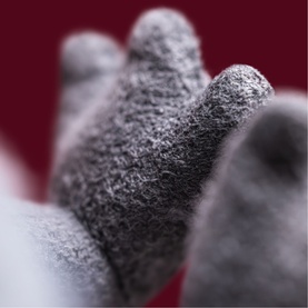 Jellycat Broox Bat 22cm grey plush toy, close-up of textured grey wing detail against red background