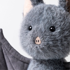 Jellycat Broox Bat 22cm grey plush soft toy, close-up of fluffy grey face with black eyes and pink nose, wing detail visible