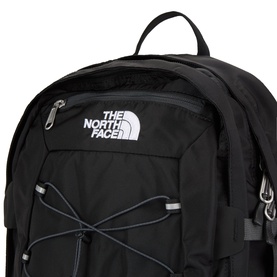 North Face black nylon backpack, close-up showing logo patch, bungee cord detail, and silver zip fastenings