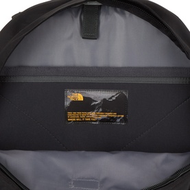 North Face black nylon backpack interior view showing main compartment lining and branded label with gold logo detail.