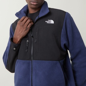 Model wearing North Face Retro Denali Fleece Sweatshirt in Summit Navy/Black, showing zip chest pockets and contrast panel detail