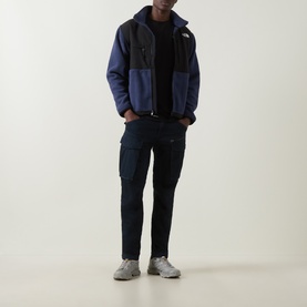 Model wearing North Face Retro Denali Fleece Sweatshirt in Summit Navy/Black with cargo trousers and grey trainers.