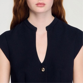 Model wearing Sandro Button Front Mini Knitted Dress in black, showing V-neckline and gold-tone button detail, sleeveless style.