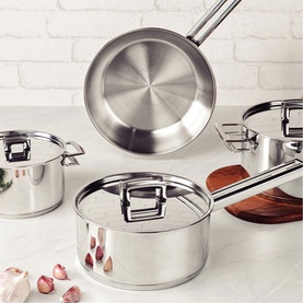 Tramontina Stainless Steel 4-Piece Cookware Set in silver, including lidded casseroles, saucepan, and frying pan, styled with garlic on marble surface