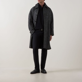 Model wearing Boggi Milano Pima Polo Shirt in black, styled with a grey herringbone overcoat, black trousers and black leather shoes.