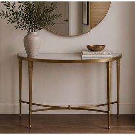 Mindy Browne Waverly Console Table in gold with glass top, styled with a round mirror, white vase with foliage and decorative bowl