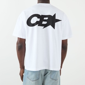Model wearing Cole Buxton white cotton T-shirt, back view showing large black CB star logo graphic, styled with light blue jeans.