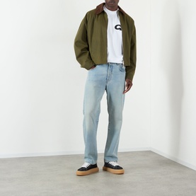 Model wearing Cole Buxton white cotton T-shirt, styled with olive bomber jacket, light wash jeans, and black gum-sole trainers.