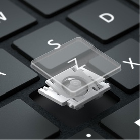 Microsoft Surface Pro Keyboard in Black, close-up of detached transparent keycap revealing white scissor-switch mechanism beneath
