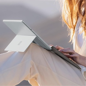 Model with Microsoft Surface Pro Keyboard with Slim Pen Storage in Black, shown attached to tablet while in use on lap