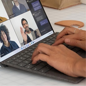 Microsoft Surface Pro Keyboard with Slim Pen Storage in Black, shown in use during a video call on a tablet display