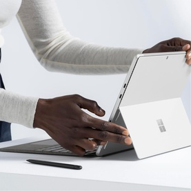 Microsoft Surface Pro Keyboard with Slim Pen Storage in Black, attached to a Surface Pro tablet on a desk with stylus alongside