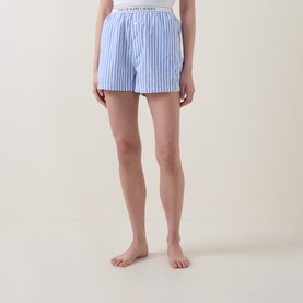 Model wearing Polo nightwear shorts in Hydrangea and Beacon Blue cotton stripe, with elasticated logo waistband.