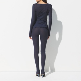 Model wearing Skims Leggings Sleet in dark grey, styled with a matching long-sleeve top and heeled mules, rear view