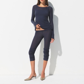 Model wearing Skims Leggings Sleet in dark grey cropped style, styled with matching long-sleeve top and silver heeled mules