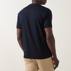 Model wearing Boggi Milano Solid Logo T-Shirt in navy blue, shown from rear, with short sleeves and straight hemline, styled with beige chinos.