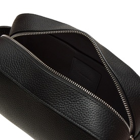 Calvin Klein Foil Logo Wash Bag in black grained leather, open top zip showing spacious interior, silver-tone hardware
