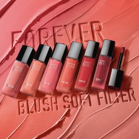 Dior Forever Liquid Blush Soft Filter collection, six bottles in varying coral and rose shades arranged on a textured pink background.