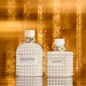 Valentino Born In Roma Ivory Donna Eau de Parfum 100ml, white studded bottles with gold hardware shown in two sizes against golden background
