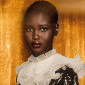Model with Valentino Born In Roma Ivory Donna Eau de Parfum, wearing white ruffled top and sequin detail against gold backdrop